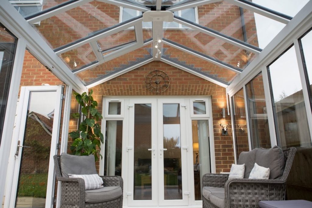 Inside a modern uPVC conservatory with a full glass roof.