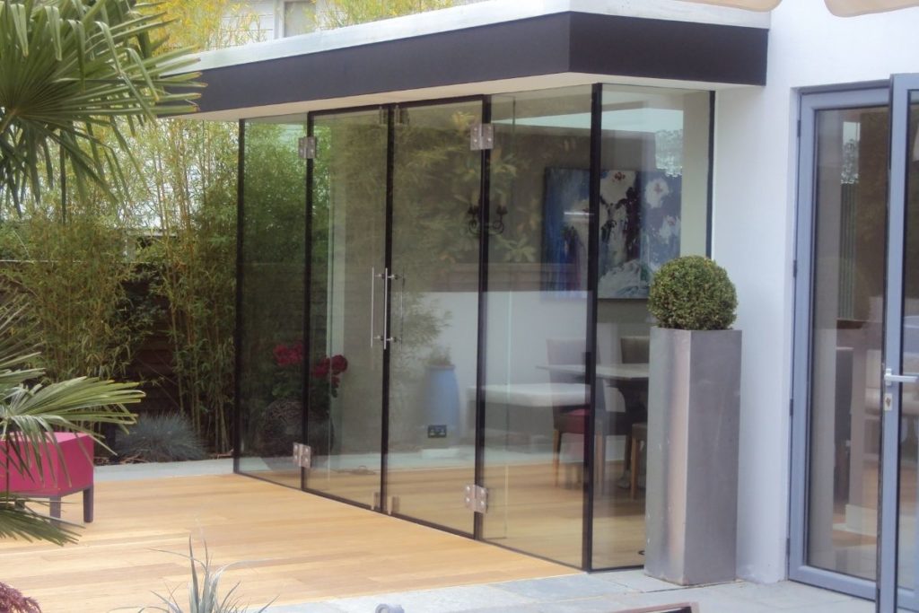 External view of a frameless glass dining extension with lantern roof