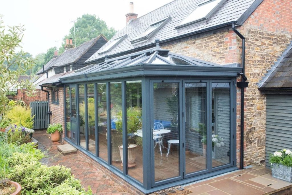 Modern bespoke slate grey aluminium conservatory with bi-fold doors