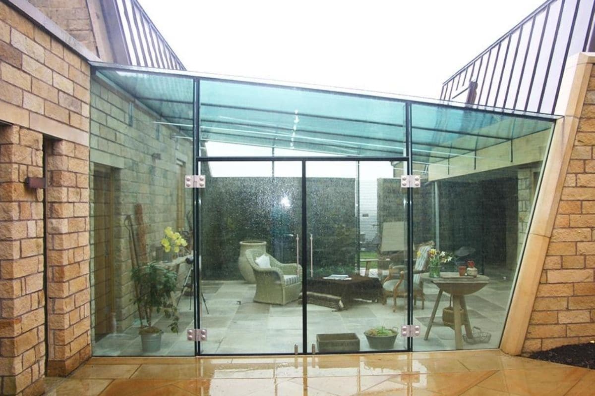 A link extension using frameless structural glass to unclose in an outside courtyard space