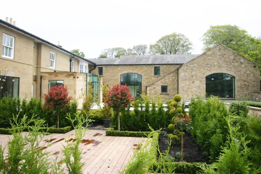 Frameless glass doors and windows are used to enclose large barn door archways, combined with a glass box extension to create a real wow factor