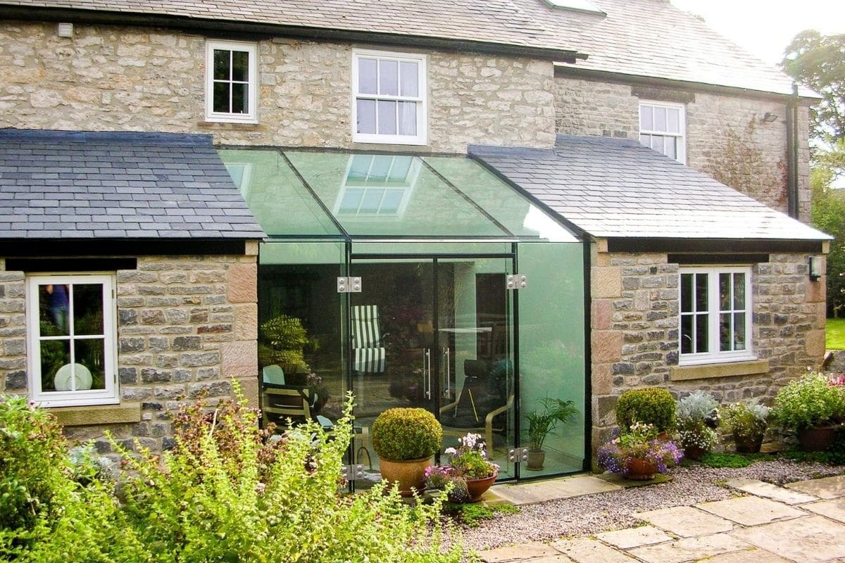 Frameless glass box linking 2 parts the existing property together