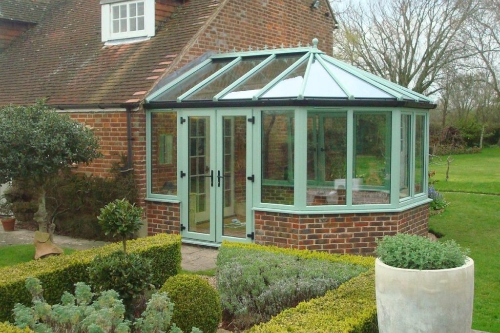 Small sage green timber conservatory with dwarf walls