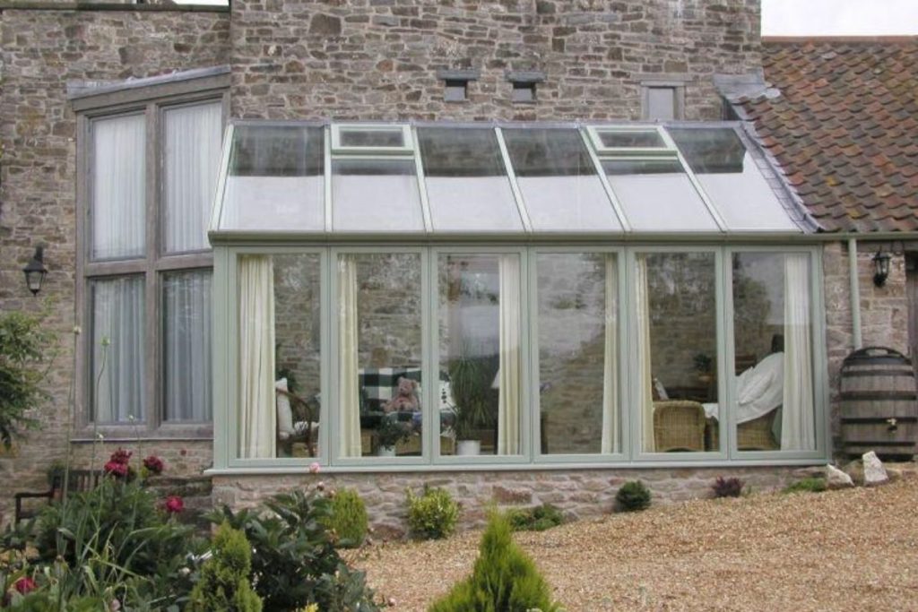 Light grey aluminium lean-to conservatory with stone dwarf walls to match the property