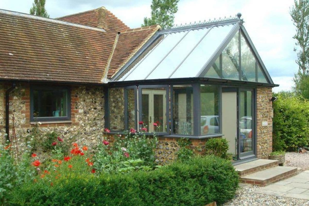 Timber framed grey gable ended porch conservatory with full and dwarf stone walls