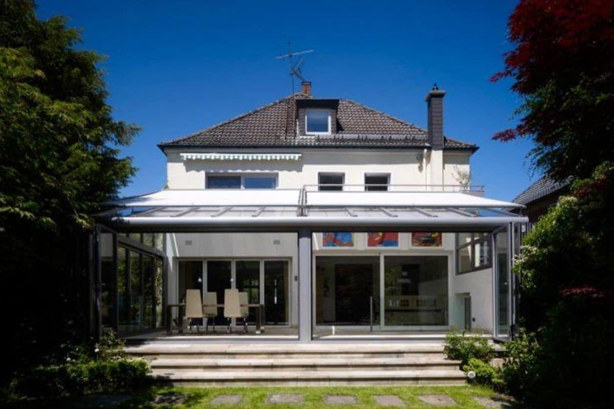 Modern aluminium lean-to conservatory dinning area with full width bi-fold doors