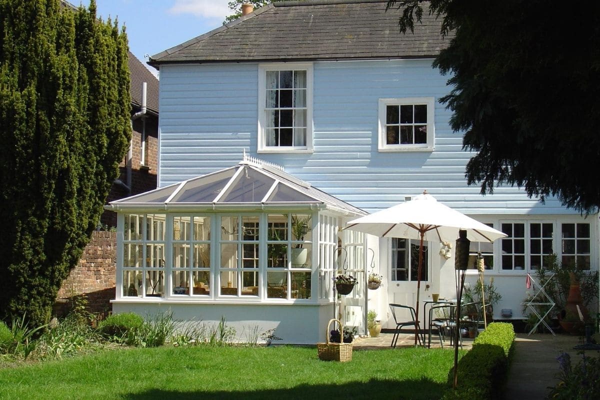 White timber framed traditional conservatory with white painted dwarf walls