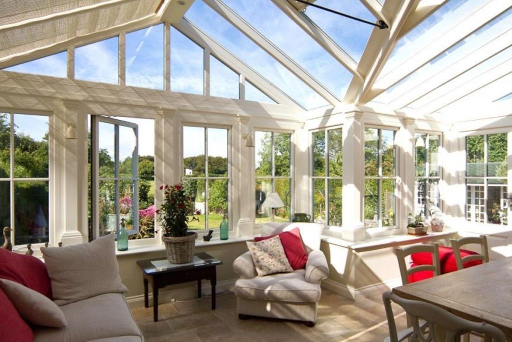 Luxurious cream timber framed conservatory with large windows and high glass roof