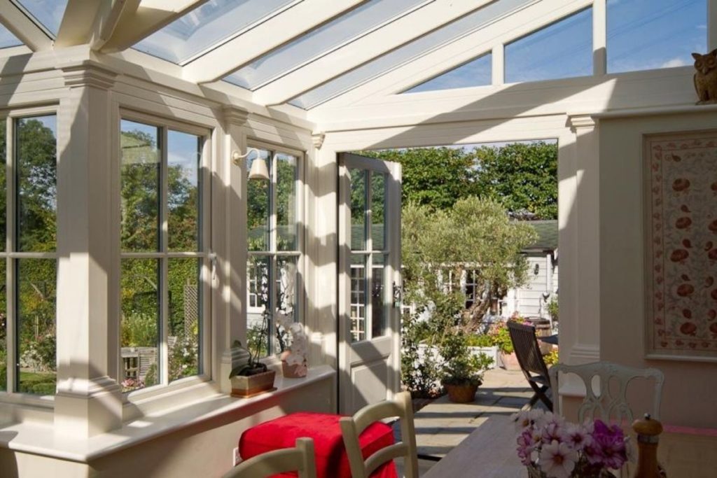 Luxurious cream timber framed conservatory with dwarf walls and double doors to the garden