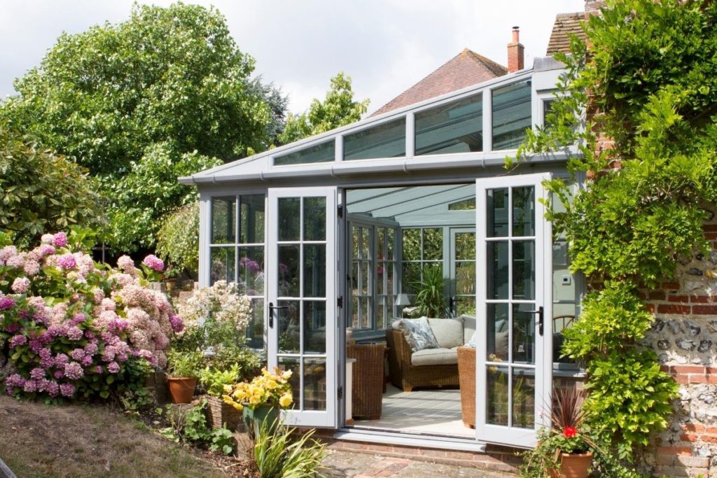 Grey timber framed lean-to conservatory with double doors out to the patio
