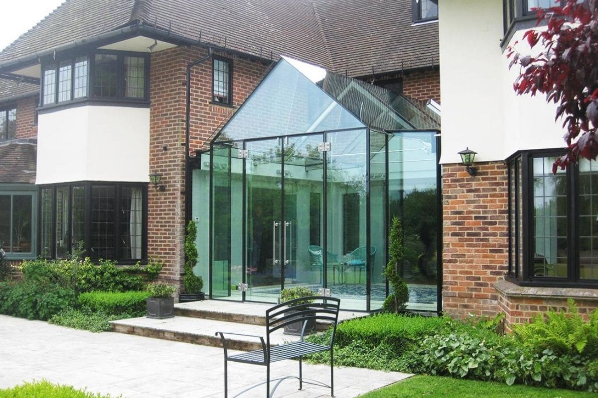 Glass box extension with a structural glass apex roof covering over a courtyard