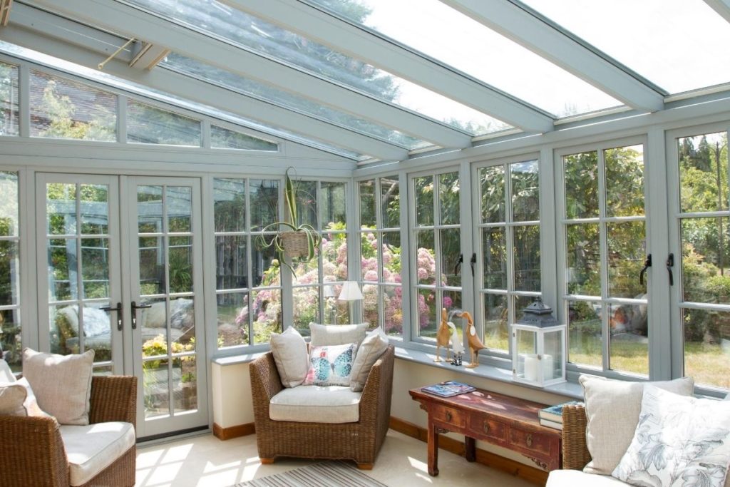 Inside a grey timber framed lean-to conservatory with roof light windows