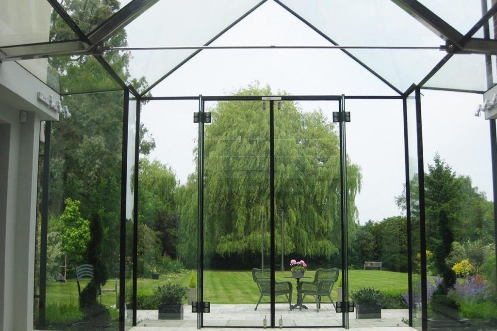 A luxury modern frameless glass box courtyard extension with beautiful un-interrupted views of the garden