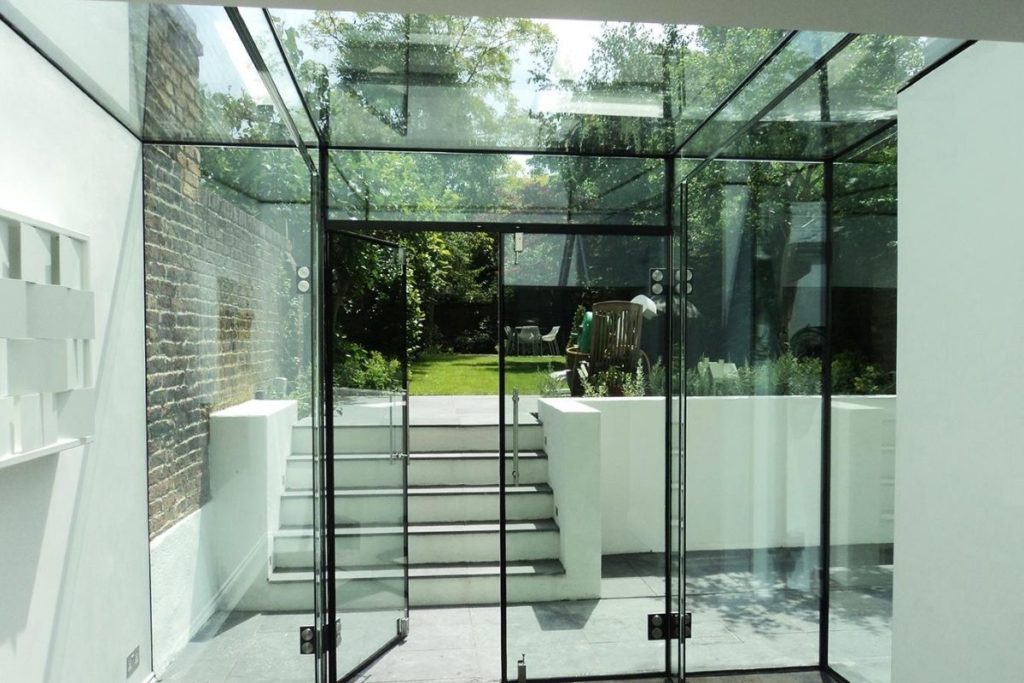 A frameless glass box extension floods light into the property and extends the living space out into the garden
