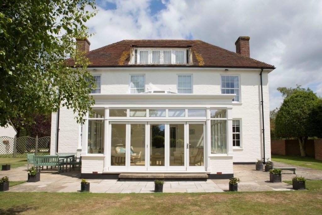 Large luxury white painted timber framed orangery extension on a West Sussex country house