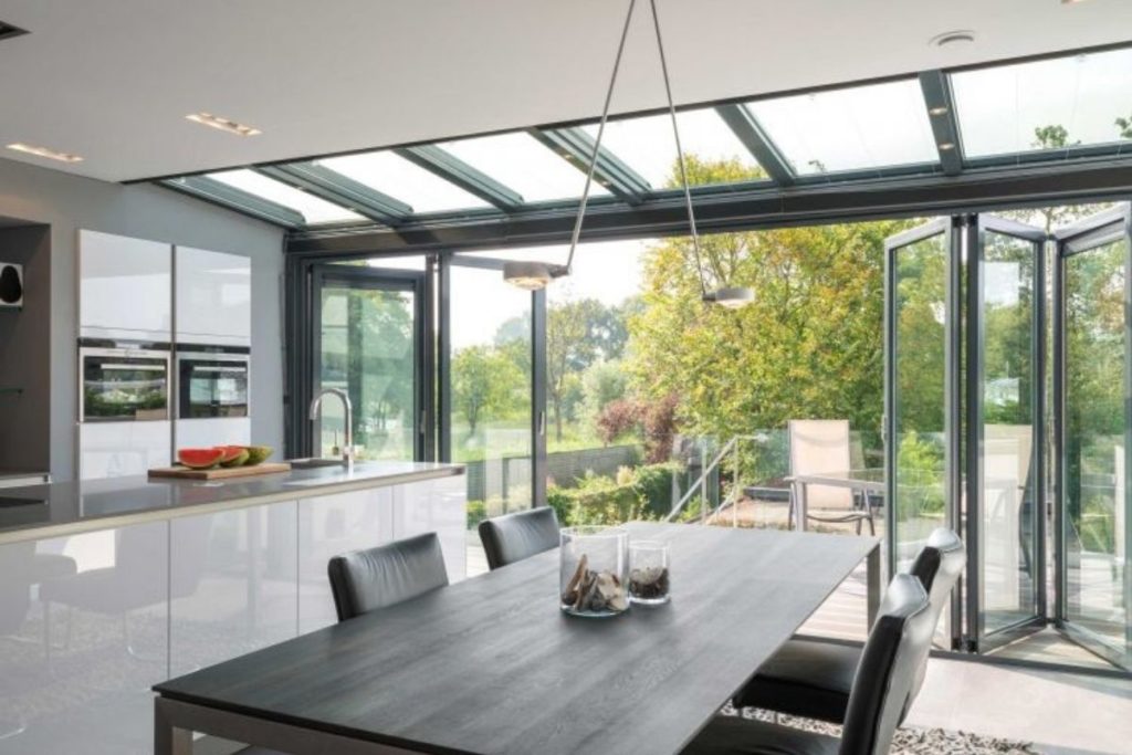 Grey aluminium framed lean-to conservatory kitchen extension with bi-fold doors