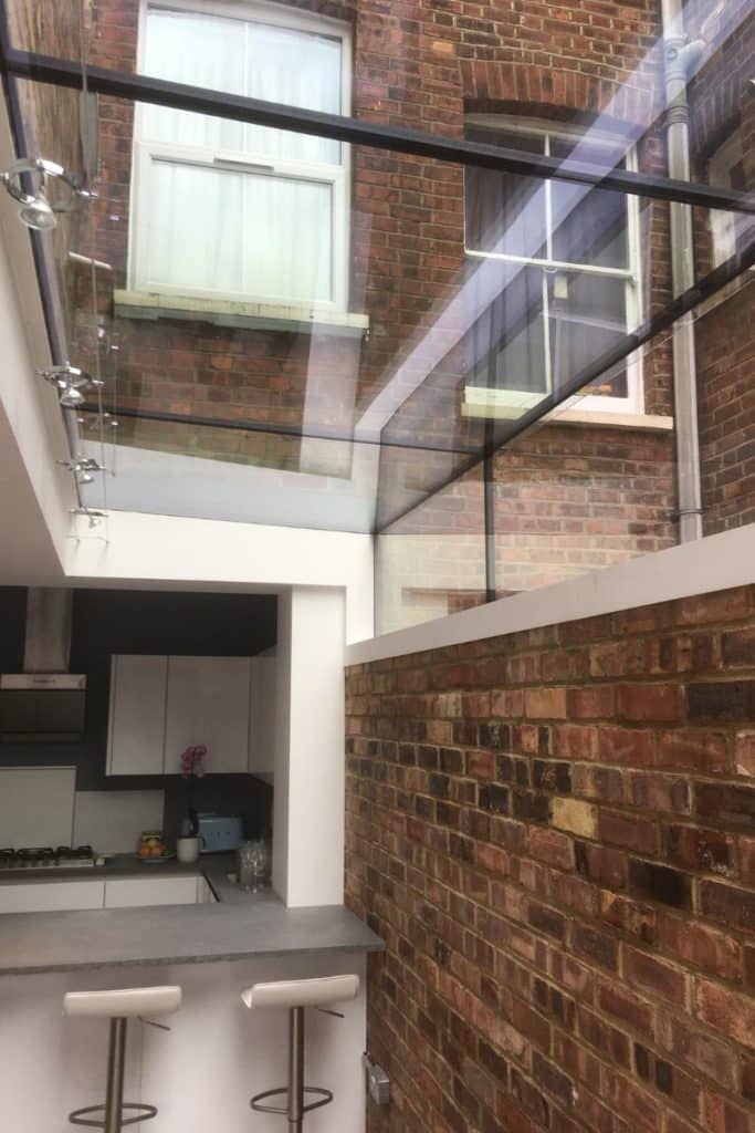 Frameless glass open roof skylight brightening up a kitchen-diner