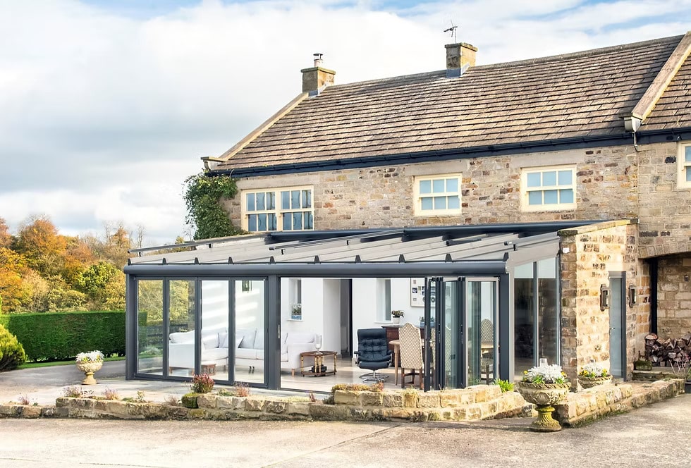 Design-led aluminium orangery with slim dark frames and glazed roof