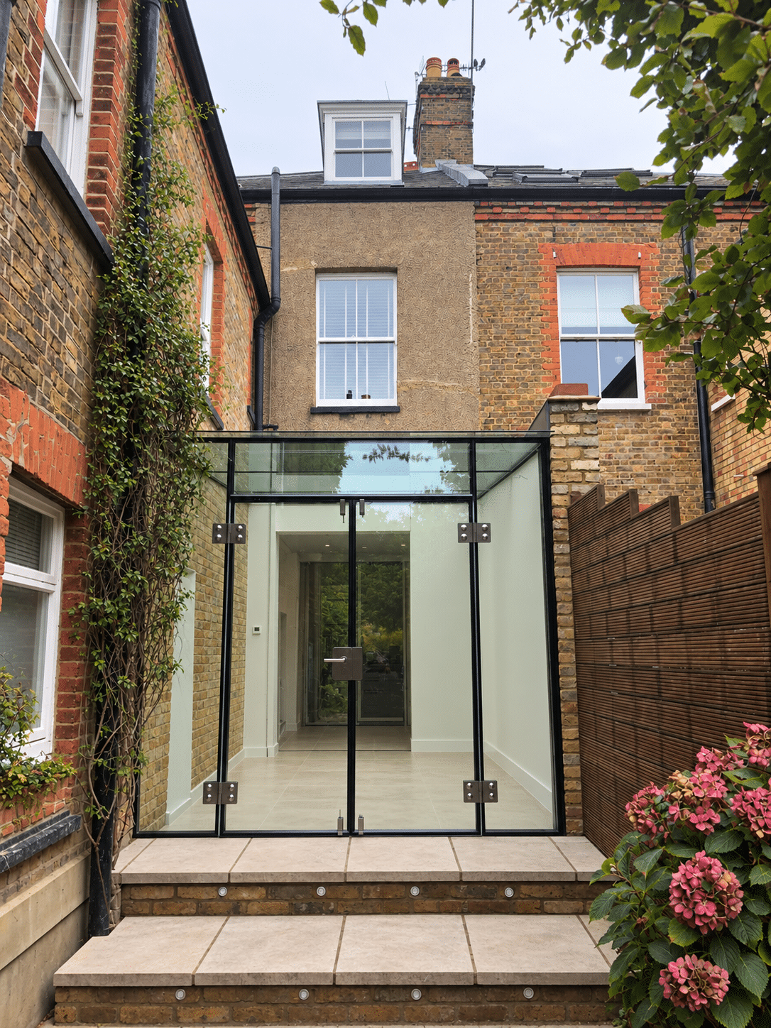 Glass box extension on a London terrace with steps