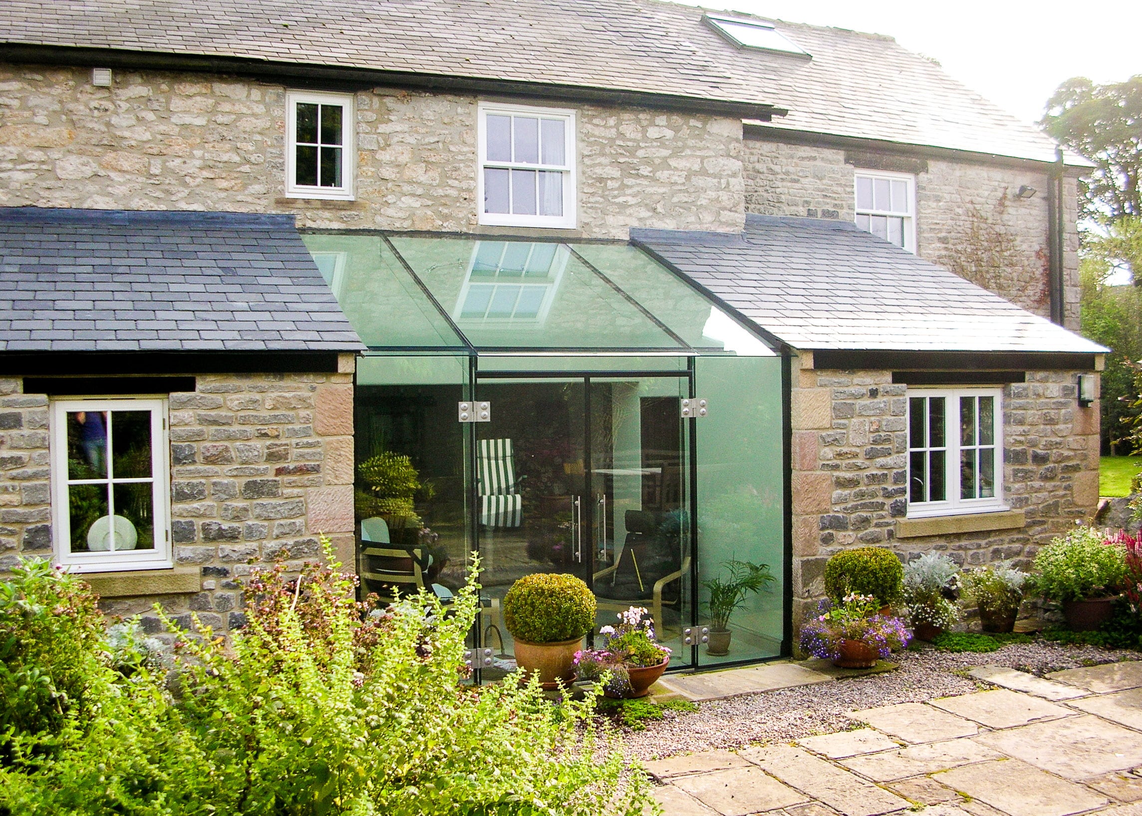 Glass link extension creating space and light on a stone house